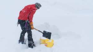 Andre filling pails with snow to melt for water